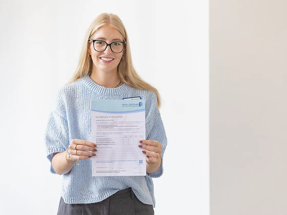 Eine junge Frau mit einem Fragebogen in der Hand.