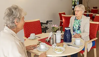 Zwei Frauen an einem gedeckten Tisch.