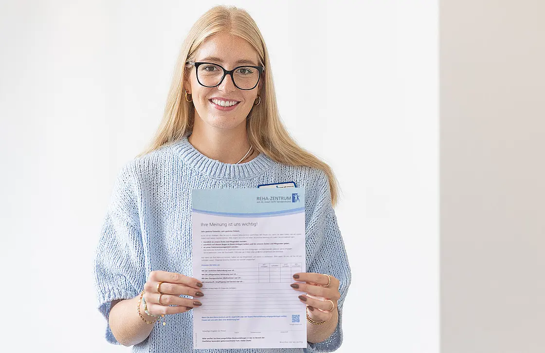 Annika Harbert hält einen Fragebogen zur Patientenzufriedenheit des Reha-Zentrums am St. Josef-Stift in den Händen.