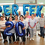 Ein Foto von einer Gruppe von Menschen, die in der Hand Luftballons halte, die das Wort "Perfekt" und die Zahl 20 ergeben.
